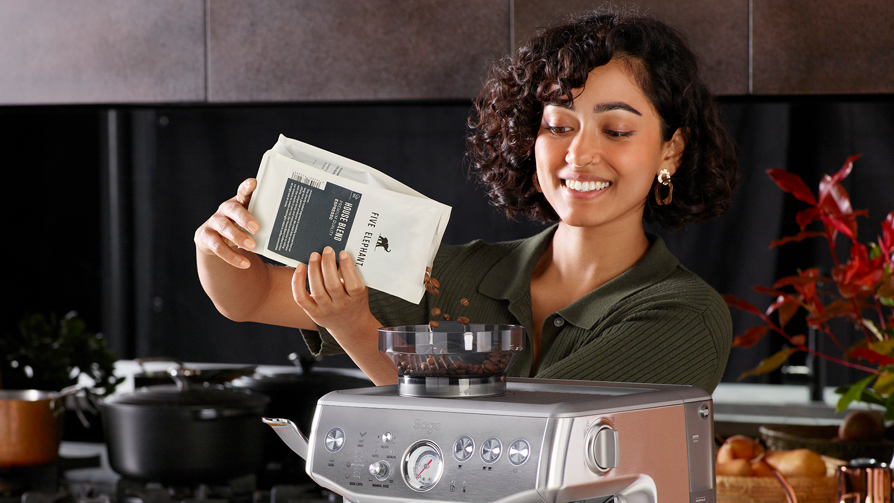 woman putting coffee beans in espresso machine