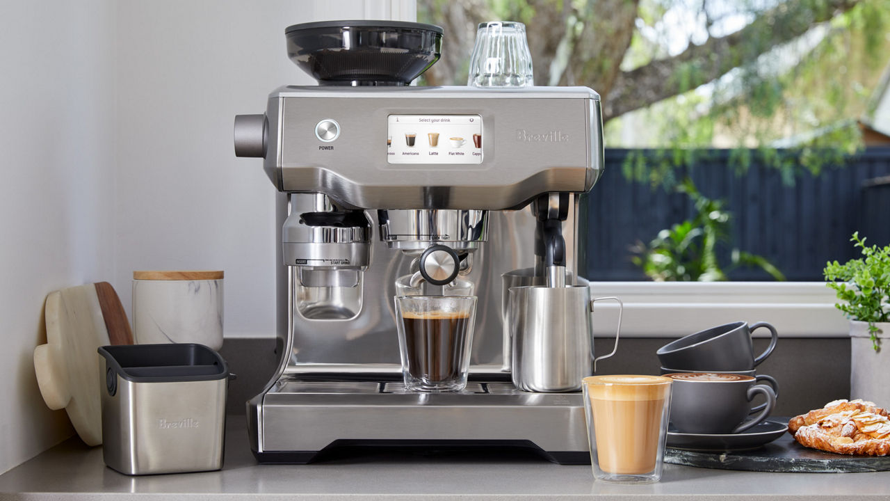Espresso machine on bench with coffee and pastries