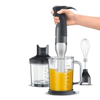 Holding blender in a jug of juice
