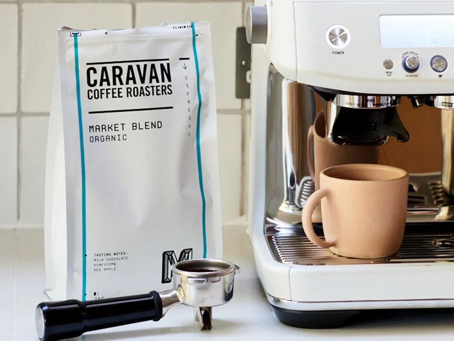 woman putting coffee beans in espresso machine