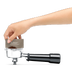Someone using the Razor precision tool to remove excess ground coffee from the portafilter.