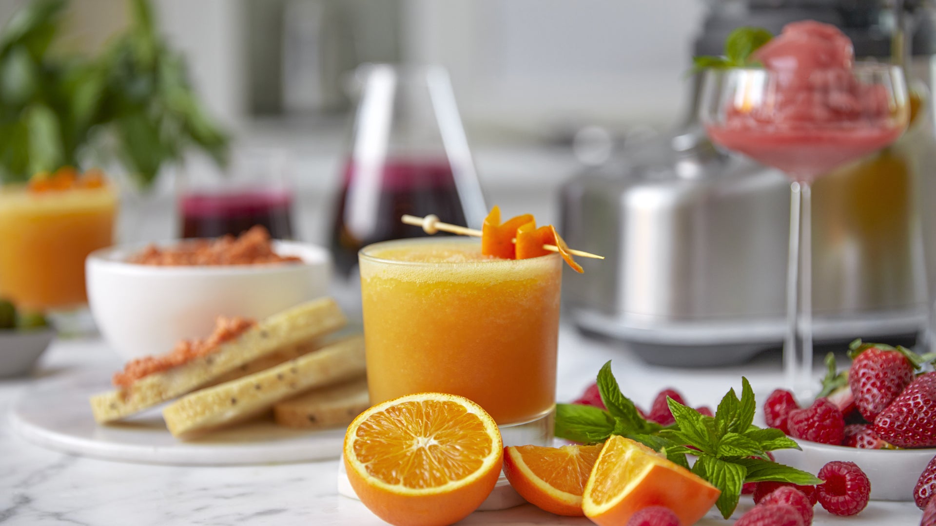 Glass of orange juice shown with citrus and berries.