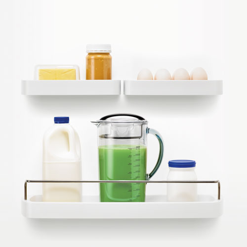 선반 위에 녹색 주스가 들어있는 주스 용기와 우유, 버터가 놓여져있다.