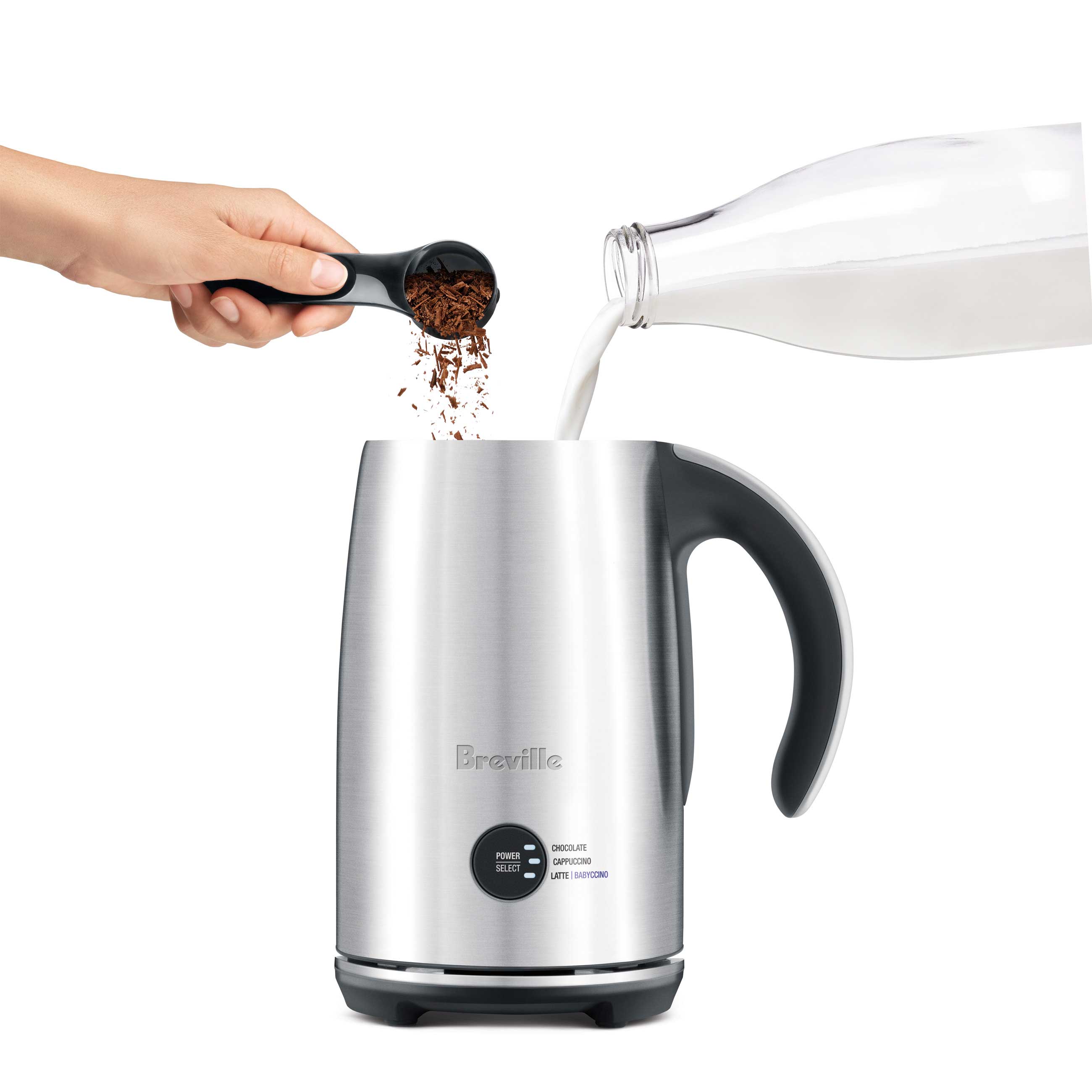 Milk frother open with milk and chocolate flakes being added.