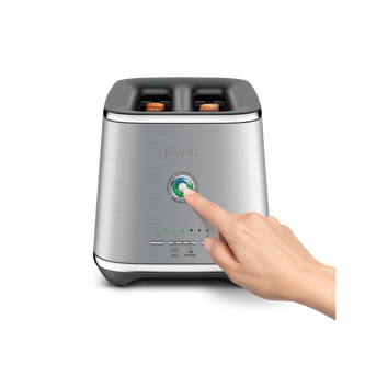 A hand reached out to press a button of the Eye Q™ Auto 2 Slice