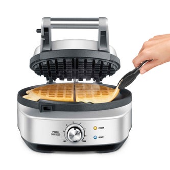 Person removing waffle from the non stick waffle maker.