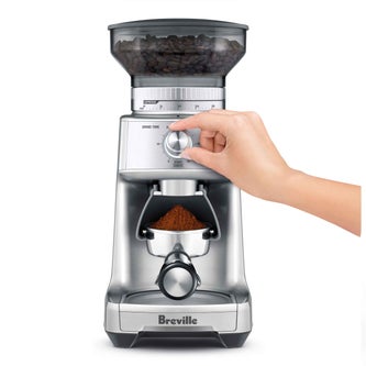 User selecting grind size using the setting wheel.